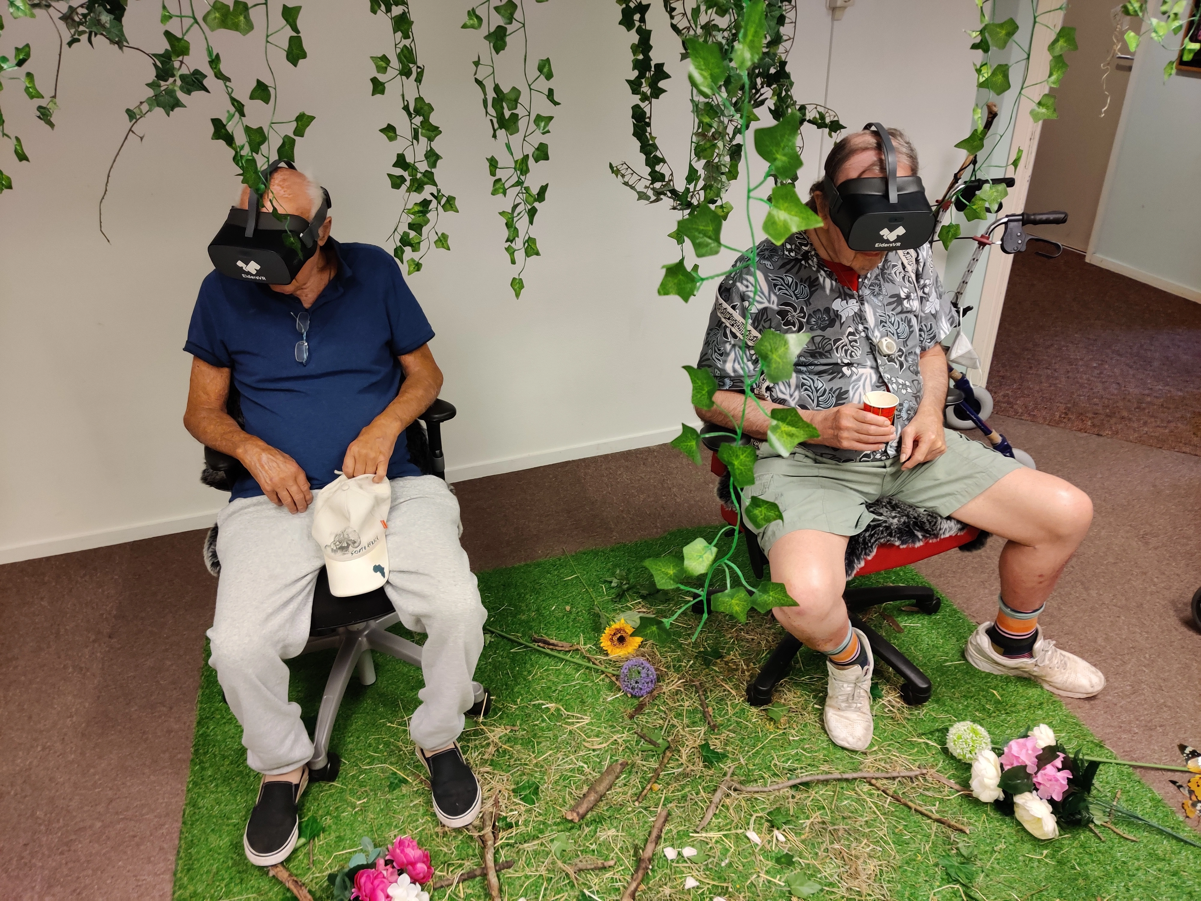 Two elderly people with a virtual reality headset on their head, watching a 360 degrees video